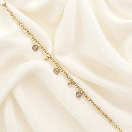 Elegant gold-plated charm bracelet with delicate round charms and cubic stones on wrist