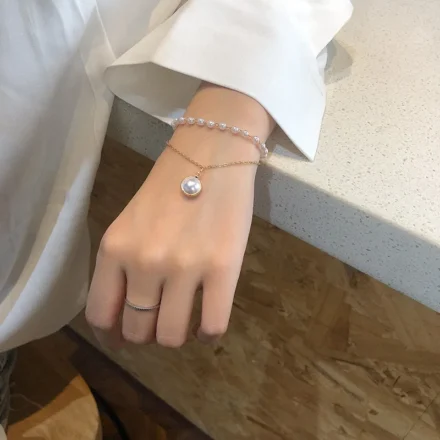 Woman wearing stylish pearl bracelet – double layer imitation pearls gold plated bracelet for women India