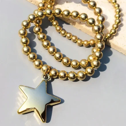 Gold beaded Starer Bracelet Stack with shiny star pendant for women.