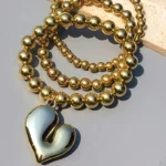 Crooked Heart Bracelet Stack Gold beaded bracelet stack with shiny crooked heart charm for women