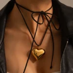18K gold plated heart pendant necklace on black rope choker worn by a woman
